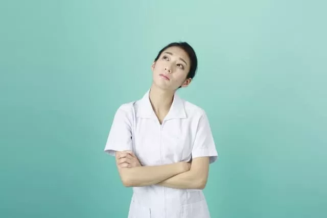 何かを考えている看護助手(看護補助)の女性