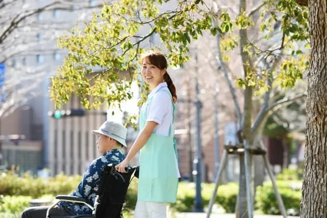 車いすを押している女性介護スタッフ