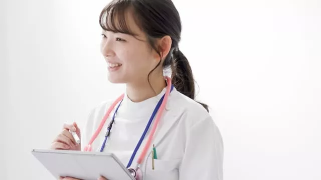 患者と話す医療事務員の女性