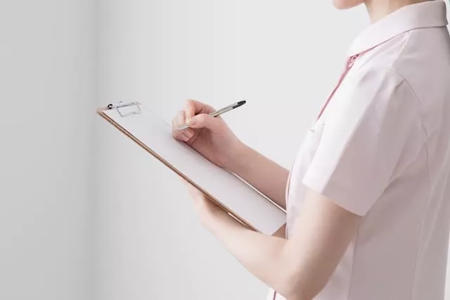 ノートに書き込んでいる医療事務スタッフ
