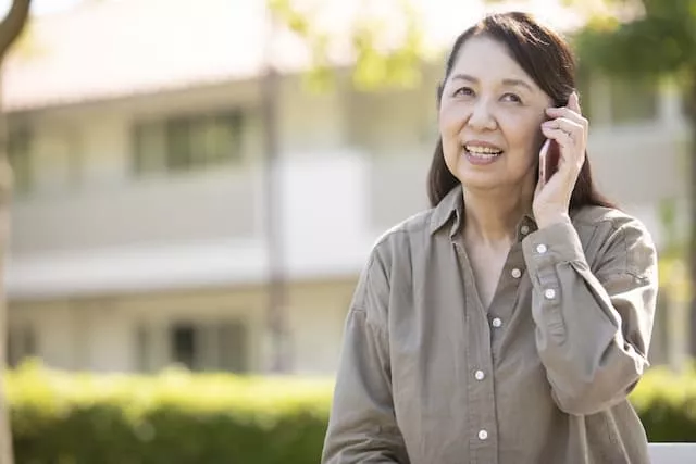 スマホで電話をかけている50代の女性