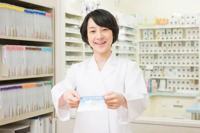 薬を差し出している薬局の薬剤師