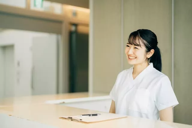 受付をしている医療従事者の女性