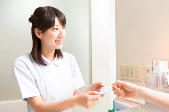 保険証を確認する外来クラークのスタッフ