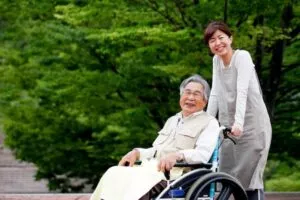 車椅子を押している介護職の女性