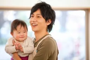 子どもを抱っこしている男性保育士