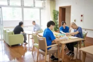 介護施設内でゲームを楽しんでいる利用者と職員