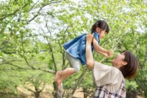 子供を抱いている保育士の女性