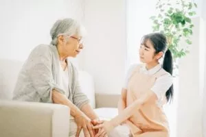 利用者の手を握っている女性介護スタッフ