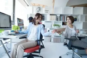 オフィスで書類を渡す営業アシスタントの女性