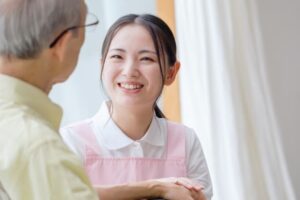 患者と接している看護助手の女性