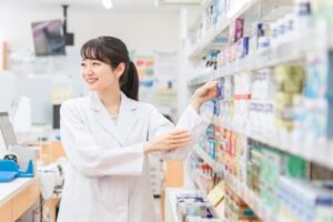 薬品の棚を確認する調剤事務の女性