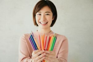 色鉛筆を持っている女性の保育士