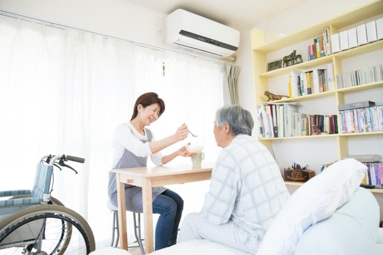 食事の介助をしている介護士の女性