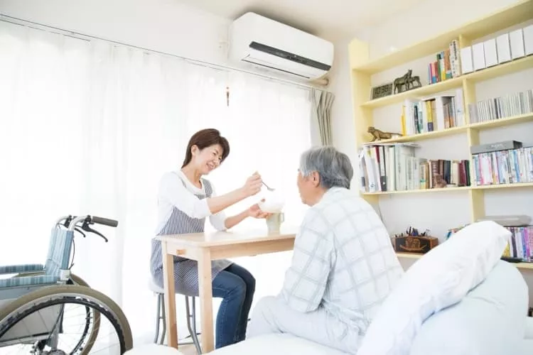 食事の介助をしている介護士の女性