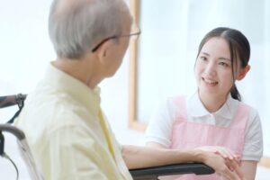 利用者の手を握る介護士の女性