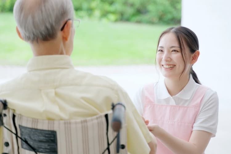 利用者の手を取る介護施設の女性