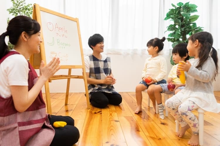 子ども達に英語を教えている保育士の男女