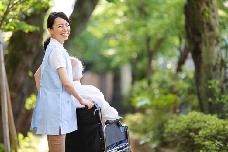 車椅子を押す介護支援専門員の女性