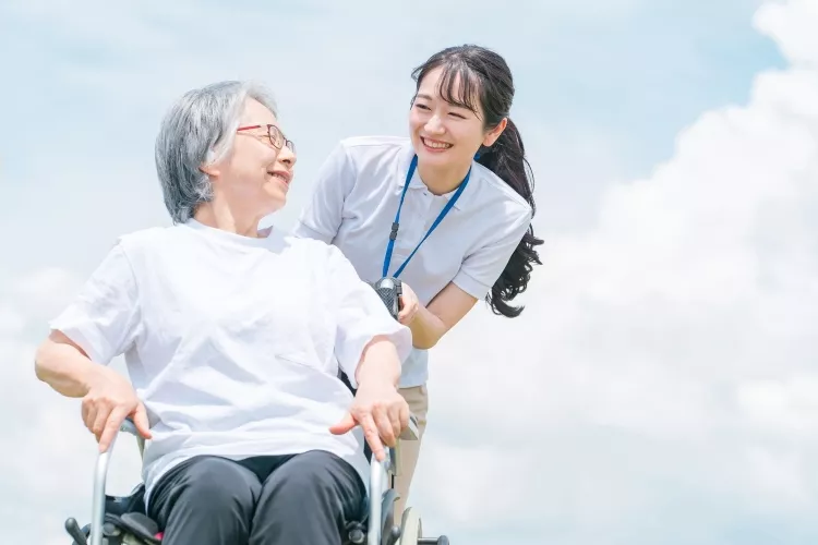 車いすに乗っている高齢者と介護士の女性