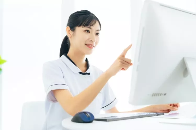 PCの画面を見ている医療事務の女性