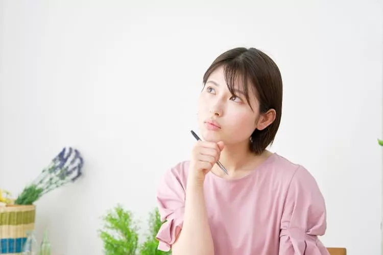 考えながら履歴書を記入している女性