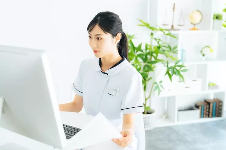 クリニックで書類の確認をする医療事務の女性