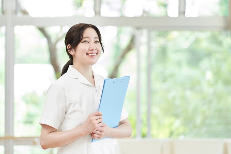 ボードを抱えている医療事務スタッフの女性
