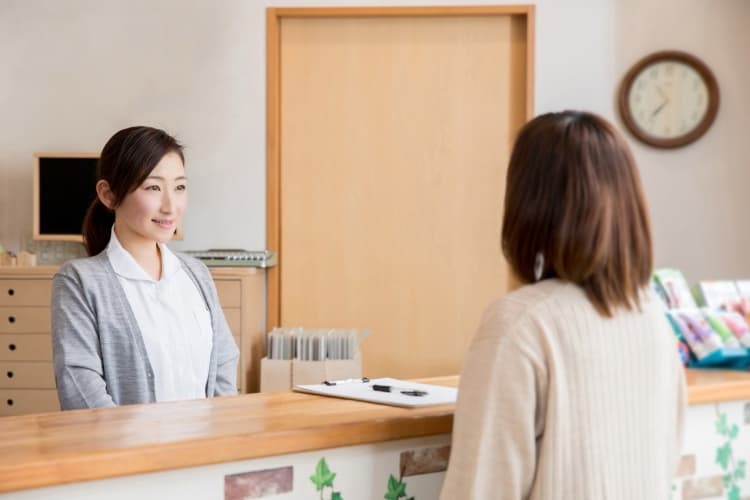 薬局で患者の対応をする医療事務女性